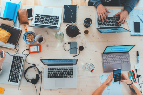 Bureau met laptops en werkende mensen